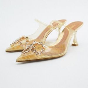 Gold vinyl heels with strap and jewel bow front